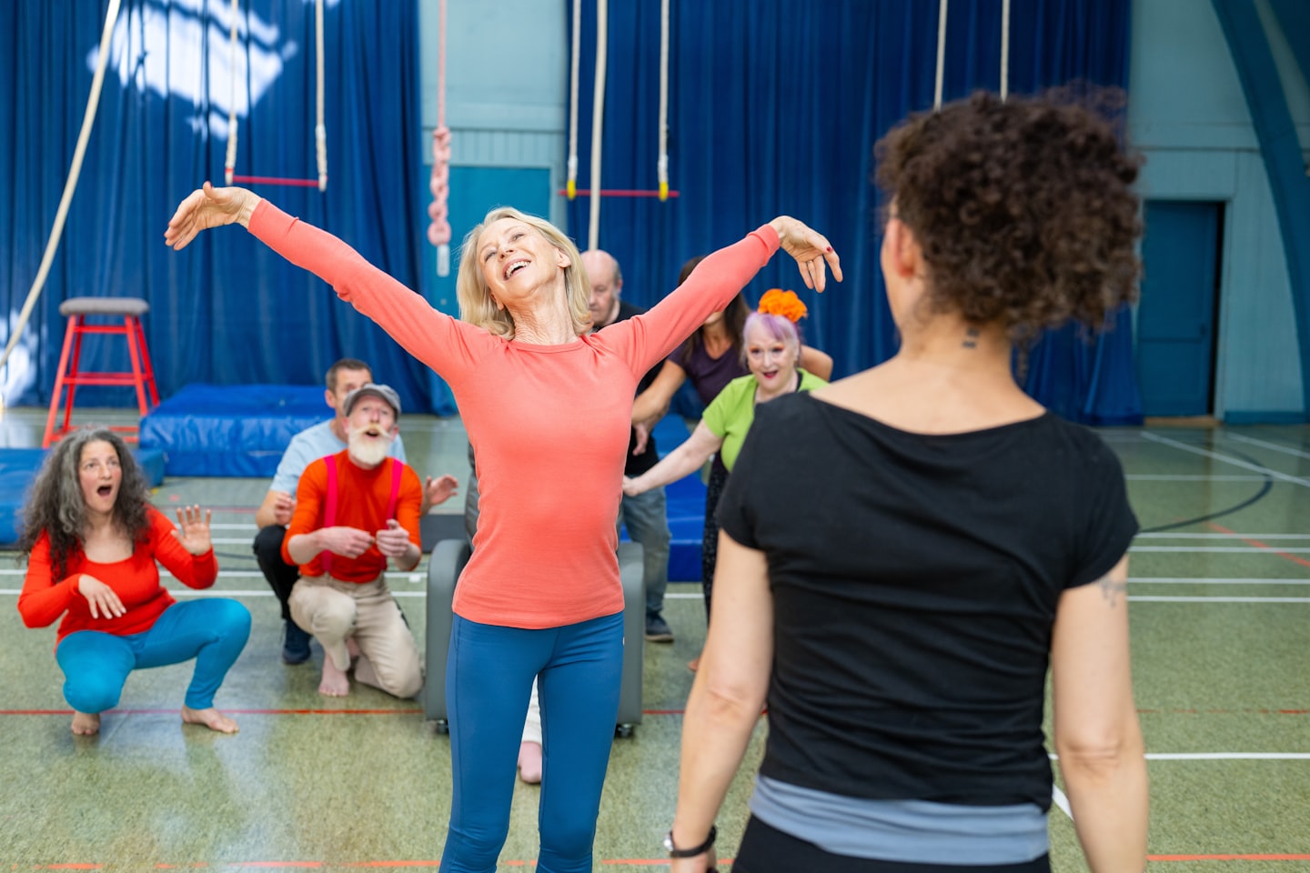 Diverse adults enjoy an energetic indoor fitness class together.